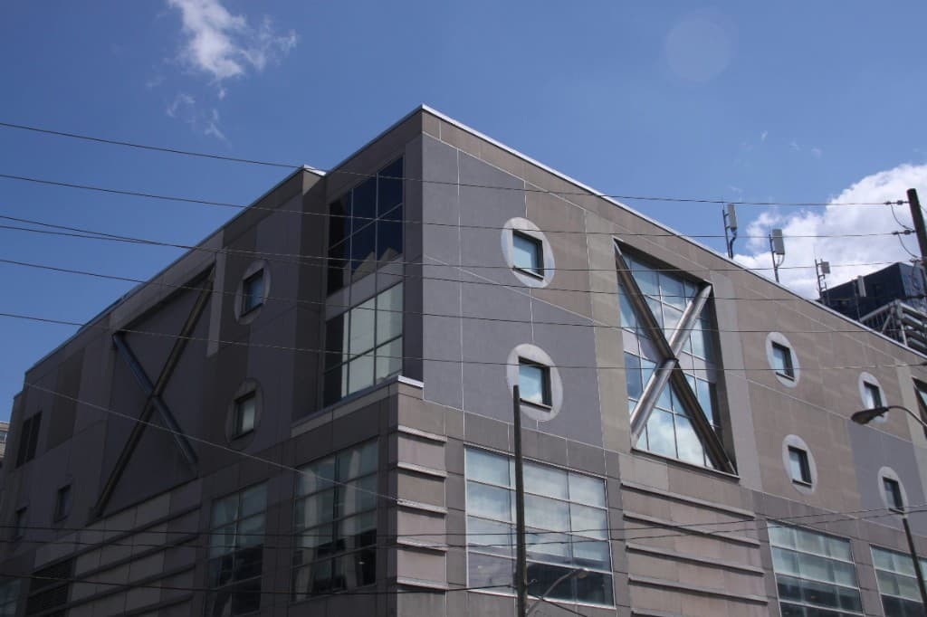 Grey ACP commercial facade with X bracing and circular windows