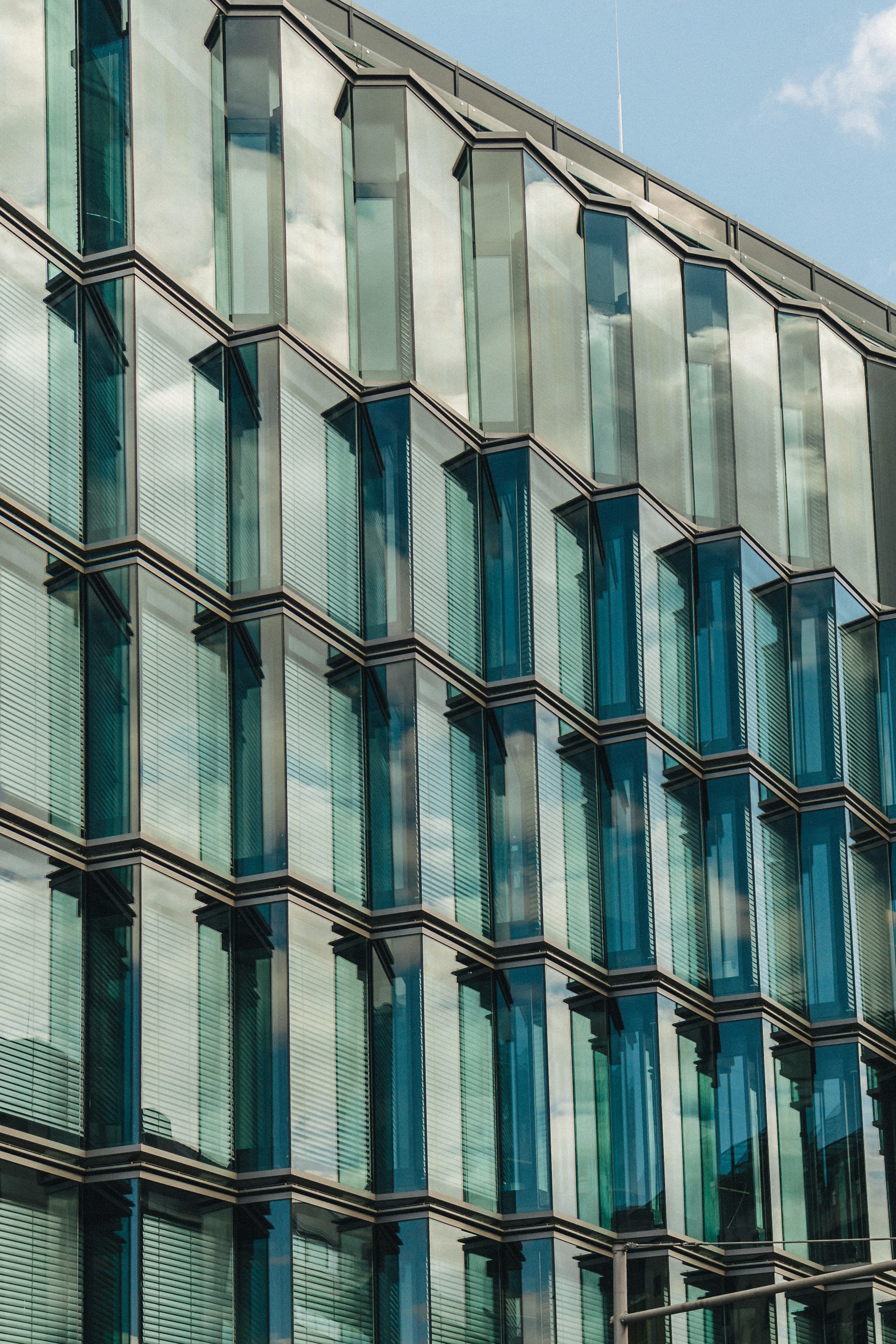 Reflective glass facade capturing sky and surrounding architecture